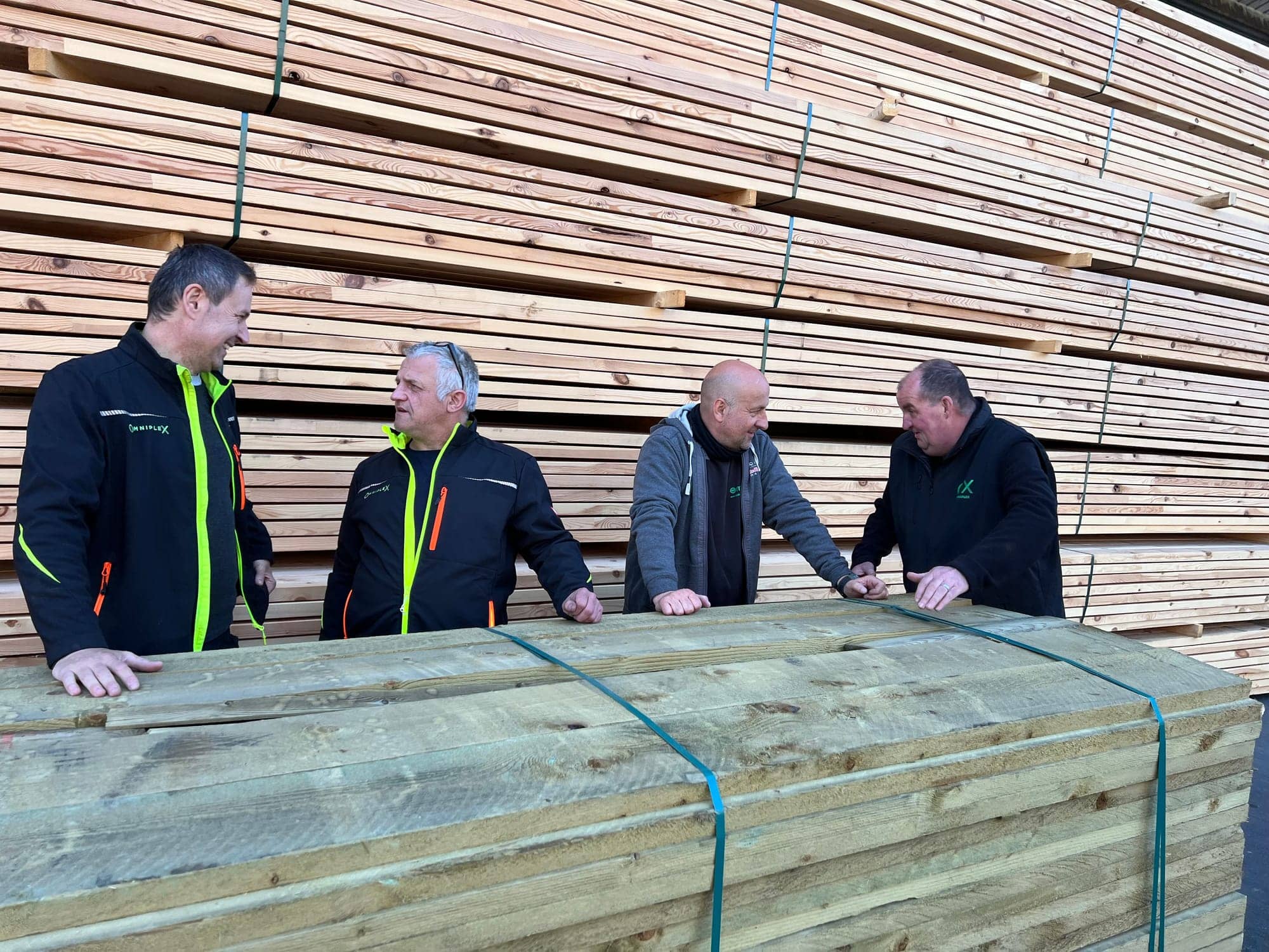 Omniplex sales reps discussing a pack of treated timber